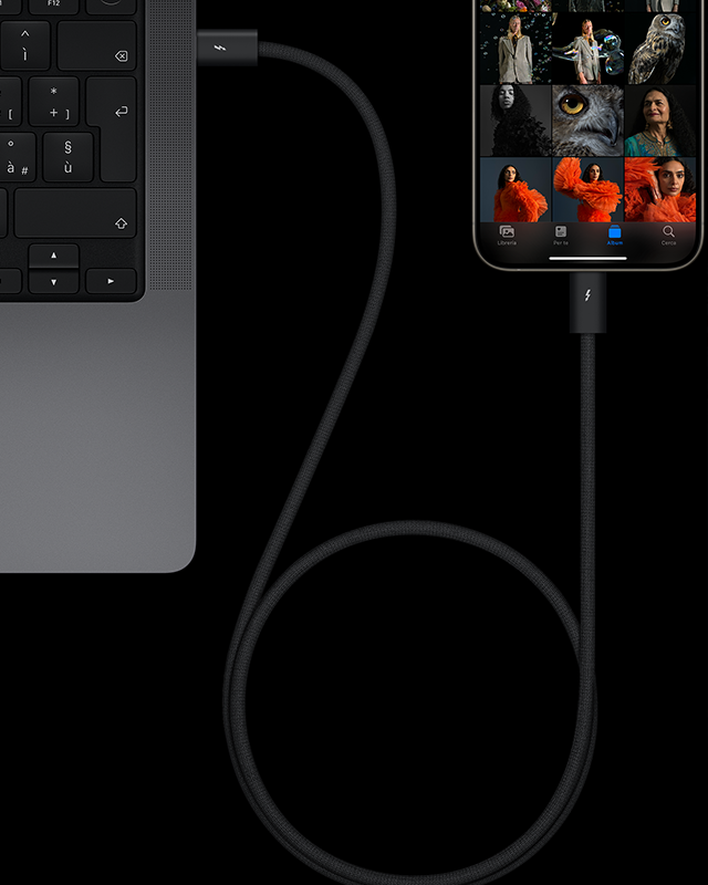 Un iPhone 15 Pro in titanio naturale con una serie di ritratti artistici sullo schermo, collegato a un MacBook Pro tramite un cavo USB-C