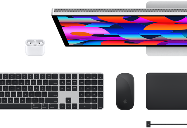 Vista dall’alto di alcuni accessori per Mac: Studio Display, Magic Keyboard, Magic Mouse, Magic Trackpad, AirPods e cavo di ricarica MagSafe