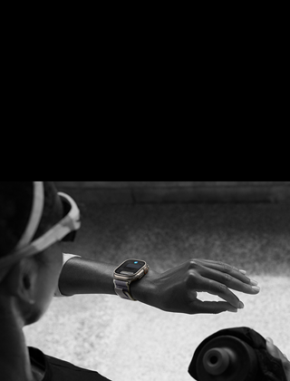 Una jogger che guarda il suo Apple Watch Ultra 2 sul polso sinistro, facendo il gesto doppio tap con l’indice e il pollice della mano sinistra